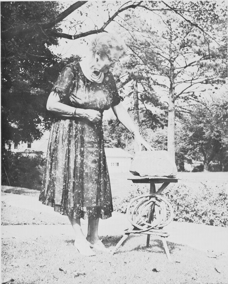 Elsie Gault is shown with a stone with the date 1867 carved into it. The stone was originally part of the springhouse near the cabin and is currently displayed in the cabin.