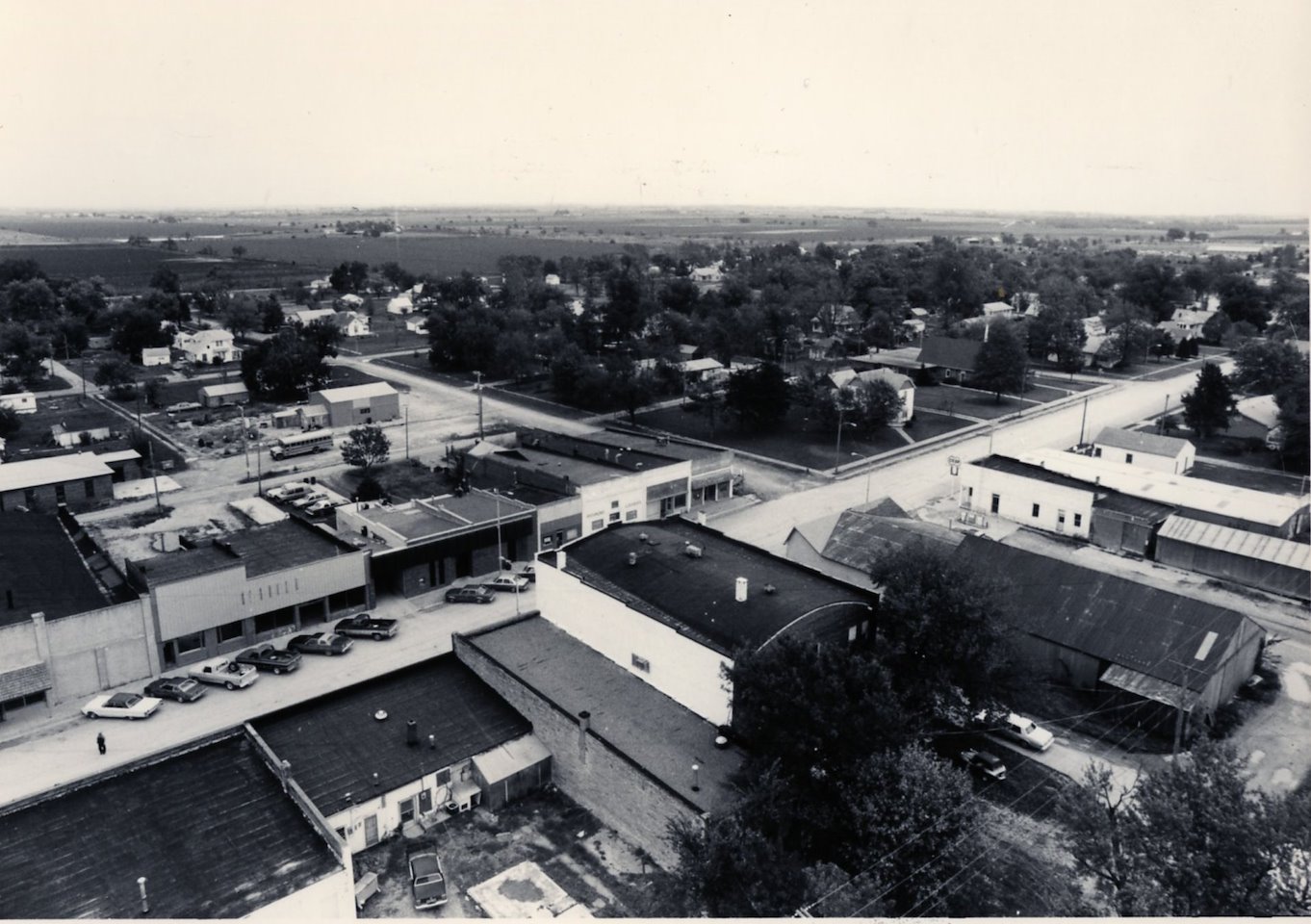 An aerial view of a street lined with businesses and cars.