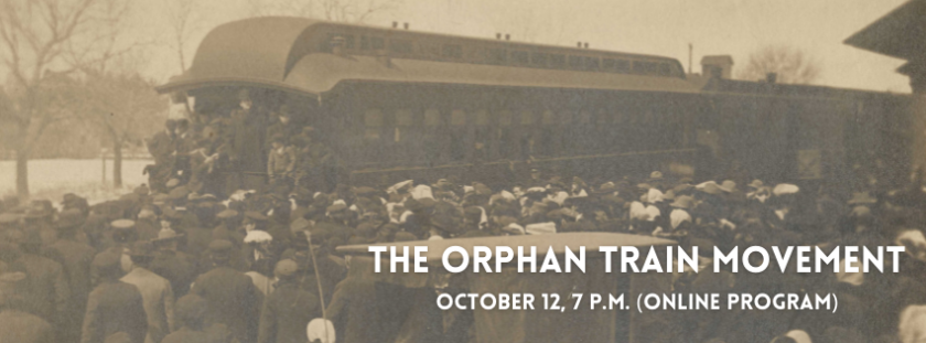 A train pulls into a station. A crowd of people gather around as passengers disembark.