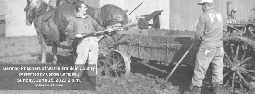 Two men in jumpsuits with "PW" on the back work in an agricultural setting.